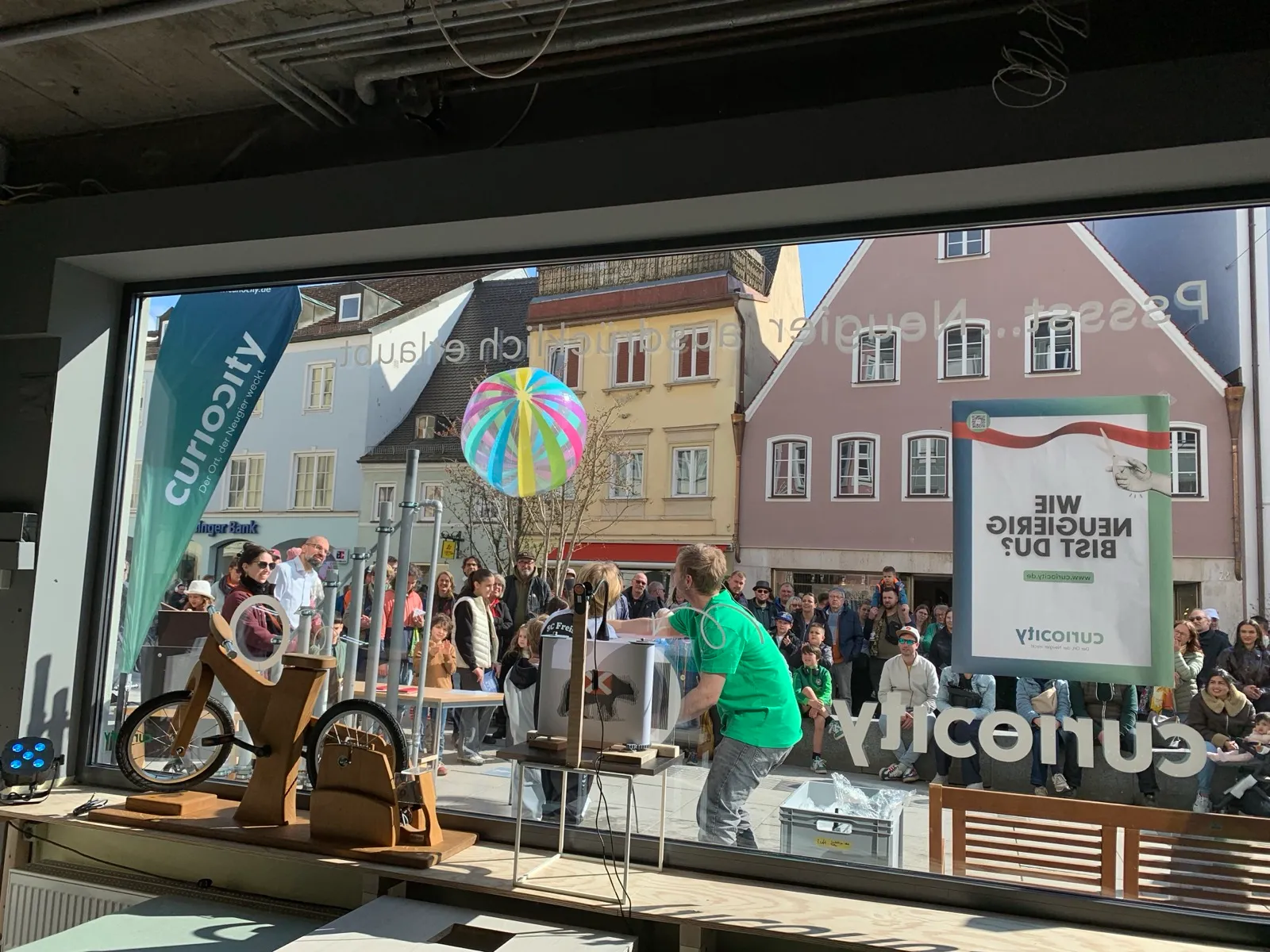 Schaufenster des Pop-up Science Centers in der Freisinger Innenstadt mit Publikum davor